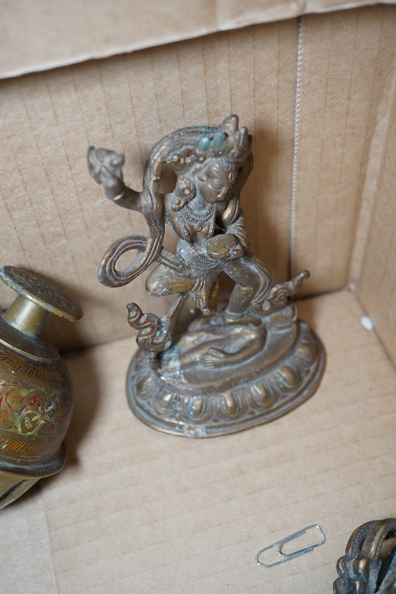 A group of Tibetan brass and mixed metal artefacts to include a brass vase with cabochon inset stones and figures of deities, largest 22cm high. Condition - mostly fair